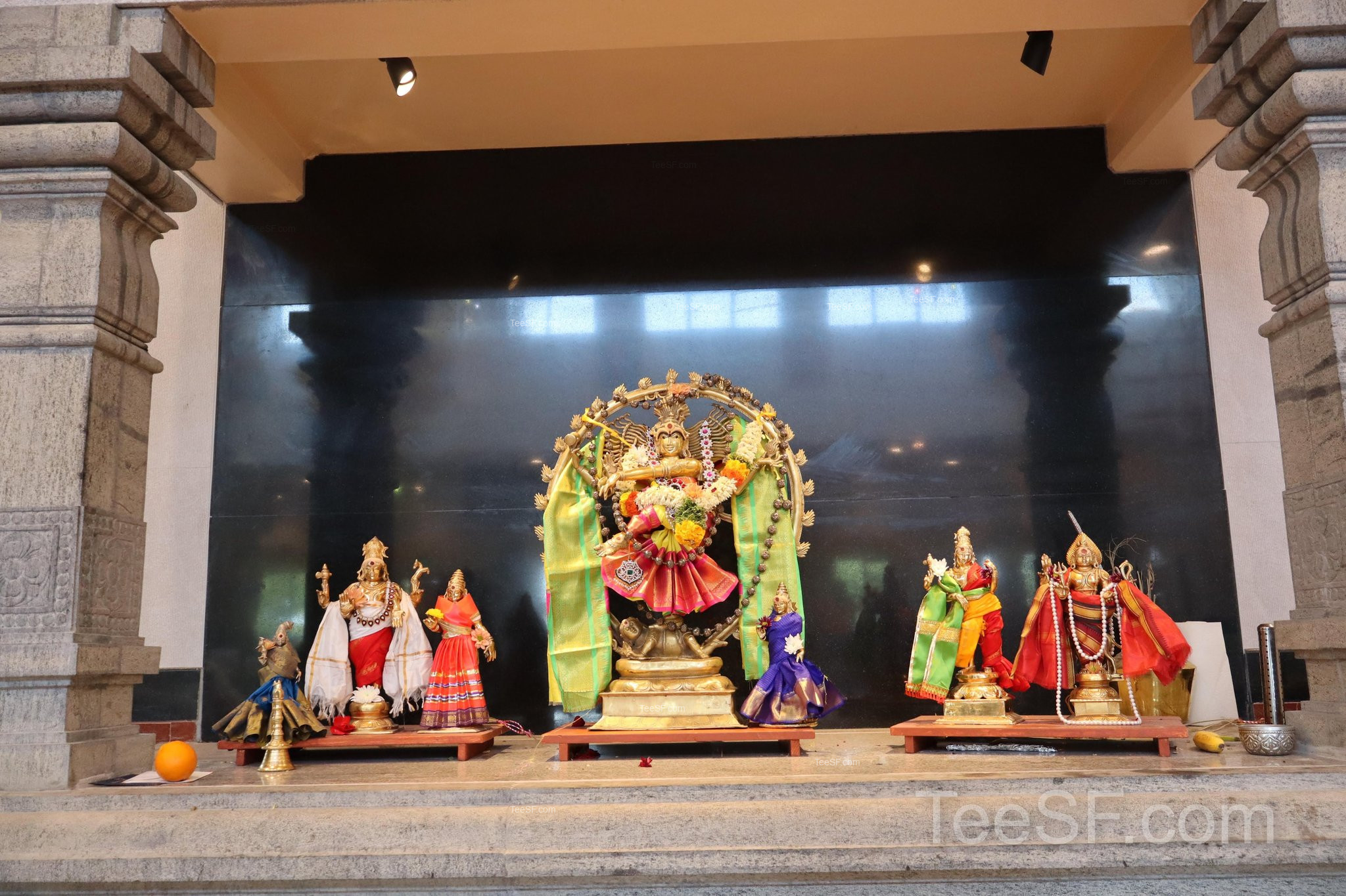A wide shrine arrangement with colorful figures and soft temple light.
